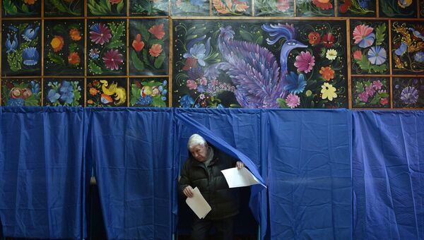 Мужчина с бюллетенями выходит из кабинки для голосования. Украина, архивное фото