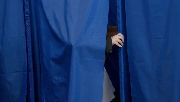 Избиратель в кабинке для голосования на досрочных выборах депутатов парламента Украины