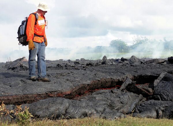 Геолог из Гавайской Вулканической обсерватории стоит на остывшем потоке лавы вулкана Килауэа, Гавайи, США