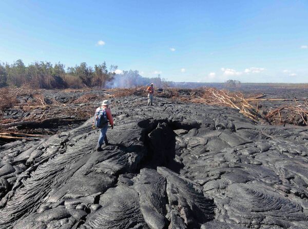 Геологи из Гавайской Вулканической обсерватории на застывшей лаве вулкана Килауэа, Гавайи, США