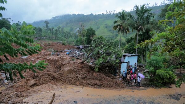 Жители стоят у разрушенного оползнем дома, округ Бадулла, Шри-Ланка