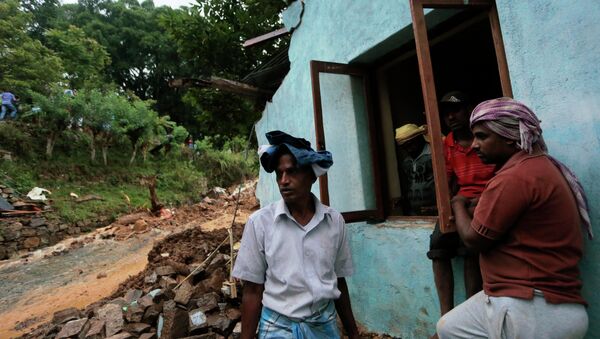 Жители стоят у разрушенного оползнем дома, Шри-Ланка. Архивное фото