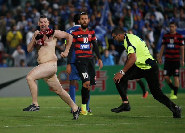 Голый мужчина бежит по футбольному полю во время матча Азиатской Лиги Чемпионов в Сиднее, Австралия