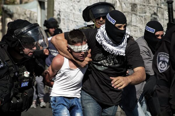 Израильская полиция задерживает молодого палестинца в ходе столкновений после пятничной молитвы в Восточном Иерусалиме. 24 октября 2014 года