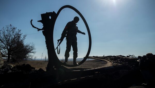 Боец ополчения ЛНР осматривает сгоревший украинский танк. Архивное фото