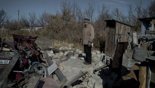Местная жительница на месте своего разрушенного дома в поселке Новосветловка в Луганской области. Архивное фото