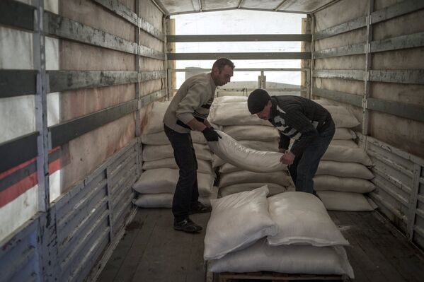 Разгрузка автомобиля с российской гуманитарной помощью в Луганске