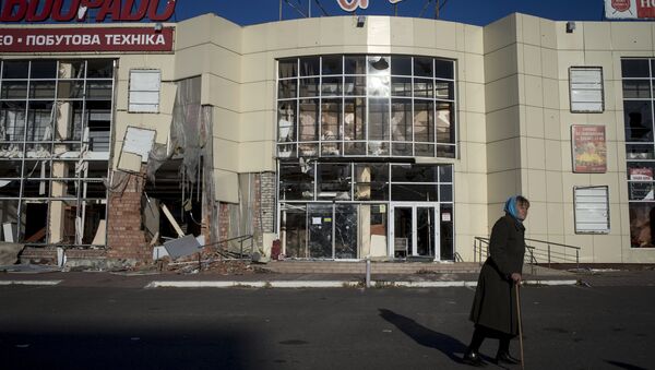 Женщина у разрушенного торгового центра в городе Луганске. Архивное фото