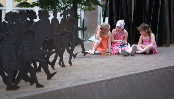 Девочки сидят у скульптуры. Льеж. Архивное фото