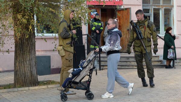 Жительница Донецка и ополченцы перед входом в избирательный участок № 125 на выборах в ДНР