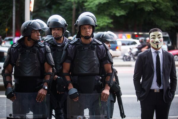 Полиция и участник марша миллионов масок в Бразилии