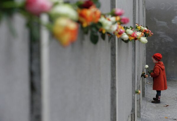 Девочка возлагает цветы во время празднования 25-ой годовщины падения Берлинской стены