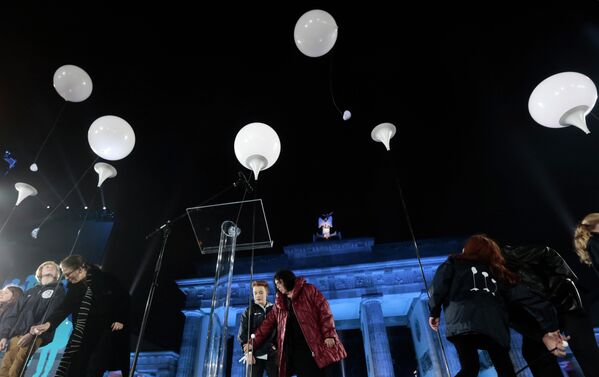 Люди запускают в небо шары во время празднования 25-ой годовщины падения Берлинской стены