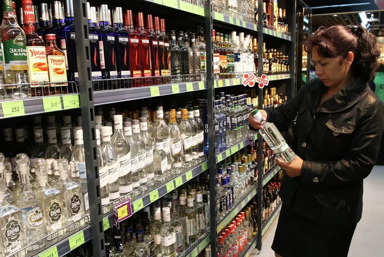 Покупательница в отделе алкогольной продукции в магазине. Архивное фото Покупательница в отделе алкогольной продукции в магазине. Архивное фото