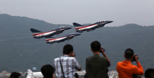 Посетители фотографирают самолеты во время авиасалоне в Чжухае
