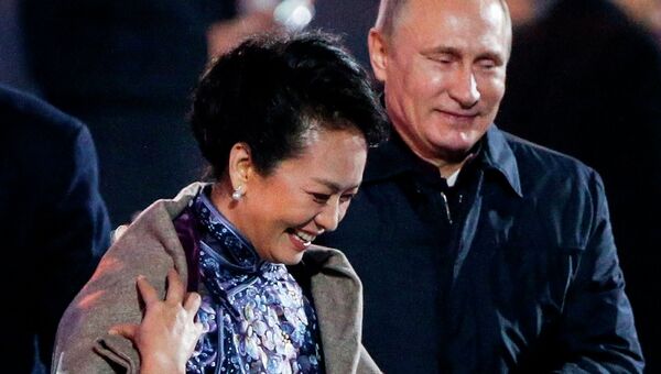 Президент России Владимир Путин накидывает пальто на плечи первой леди Китая  Пэн Лиюань