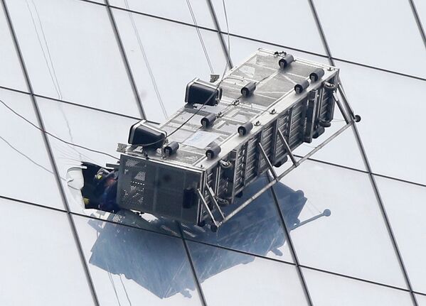 Пожарные спасают рабочих из повисшей люльки на новом здании ВТЦ в Нью-Йорке, США