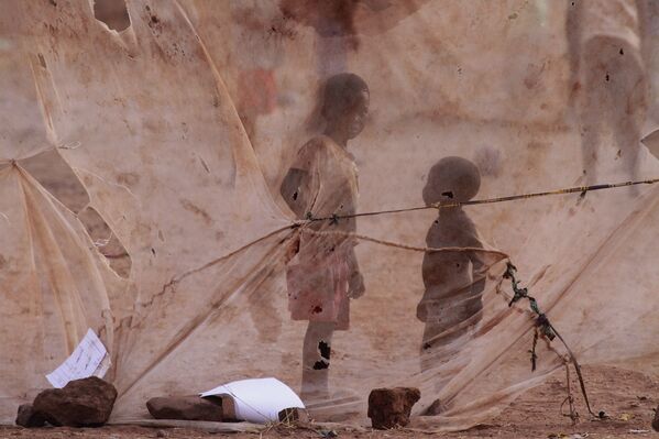 Дети видны через москитную сетку. Окраина Лусаки, Замбия
