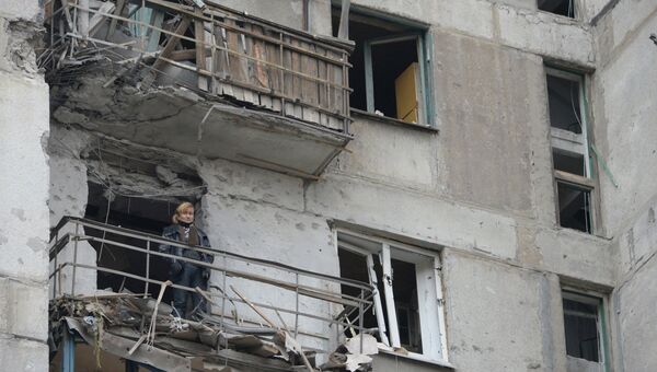 Женщина на балконе дома подвергшегося обстрелу украинскими военными. Архивное фото