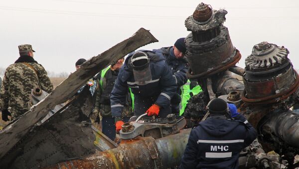 Сотрудники МЧС Донецкой народной республики пытаются распилить стойку шасси малайзийского самолета Boeing, выполнявшего рейс MH17 Амстердам — Куала-Лумпур