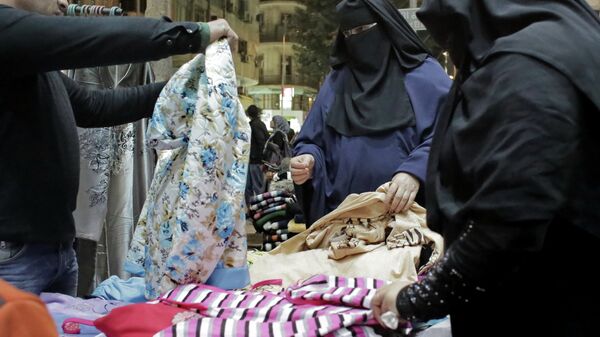 Женщины выбирают одежду на рынке