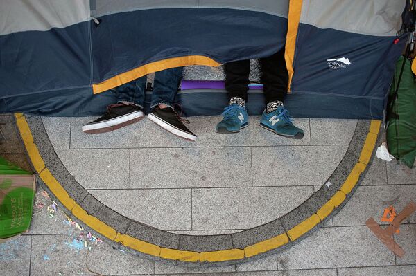 Протестующие спят в палатке возле здания Законодательного совета Гонконга после столкновений с полицией