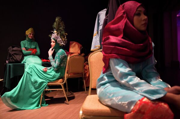 Модели за кулисами перед выходом на подиум во время фестиваля Исламской моды в Куала-Лумпуре