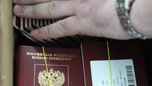 Сотрудница ФГУП Гознак упаковывает для отправки готовые биометрические заграничные паспорта граждан РФ. Архивное фото