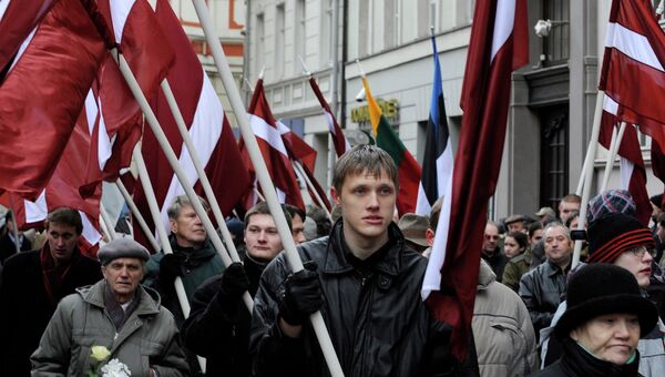 Люди несут флаги памятнику Свободы в честь солдат Латышского добровольческого легиона СС. Рига, Латвия. Архивное фото