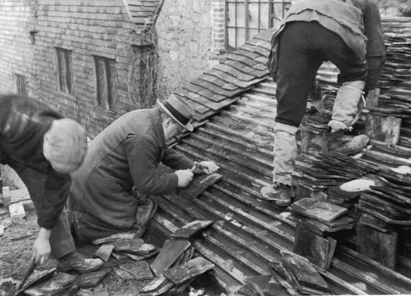 Уинстон Черчилль помогает рабочим класть плитку на крышу нового дома в графстве Кент