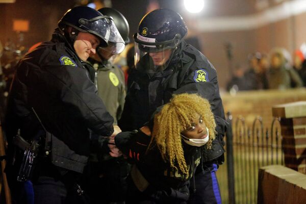 Полицейские задерживают девушку во время беспорядков в Фергюсоне