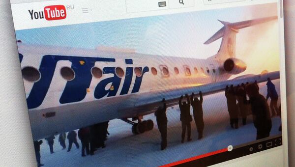 Кадр из видео, на котором пассажиры толкают самолет ТУ-134 в аэропорту Игарки