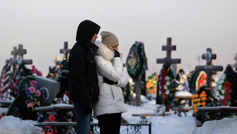 Родственники у могил погибших в результате пожара в клубе Хромая лошадь в Перми