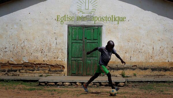 Ребенок с мячом в сельской местности Гвинеи. Архивное фото