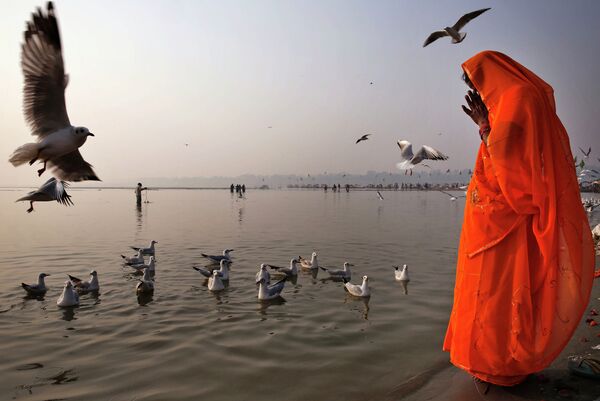 Индус молится на берегу Ганга в Аллахабаде, Индия