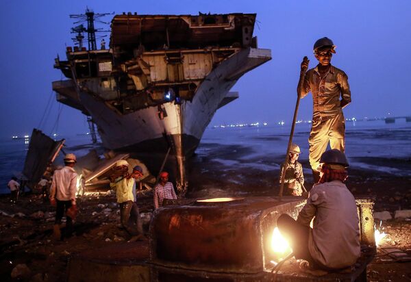 Индийские рабочие разбирают списанный на запчасти корабль