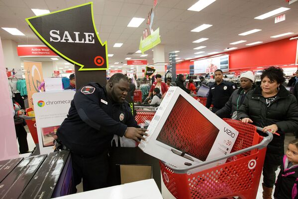 Сотрудник охраны помогает клиенту во время распродажи Black Friday в Нью-Йорке