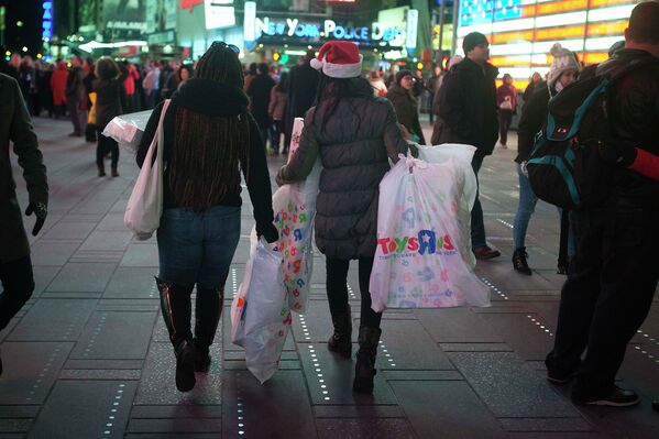 Посетители магазинов с покупками на площади Таймс-Сквер в Нью-Йорке во время распродажи Black Friday