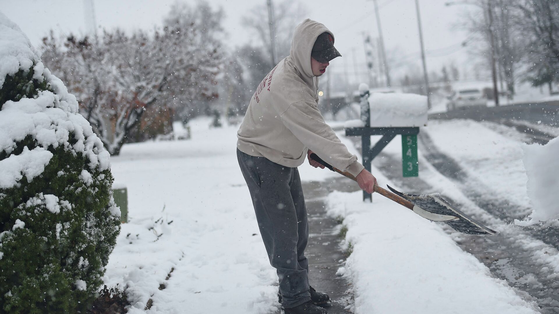 Мужчина очищает дорожку от снега в штате Пенсильвания, США. Архивное фото - РИА Новости, 1920, 04.03.2021