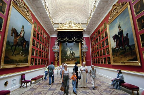 Посетители осматривают произведения искусства в одном из залов Государственного Эрмитажа