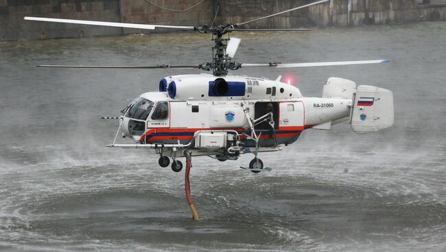 Пожарный вертолет КА-32А набирает воду из реки Москвы