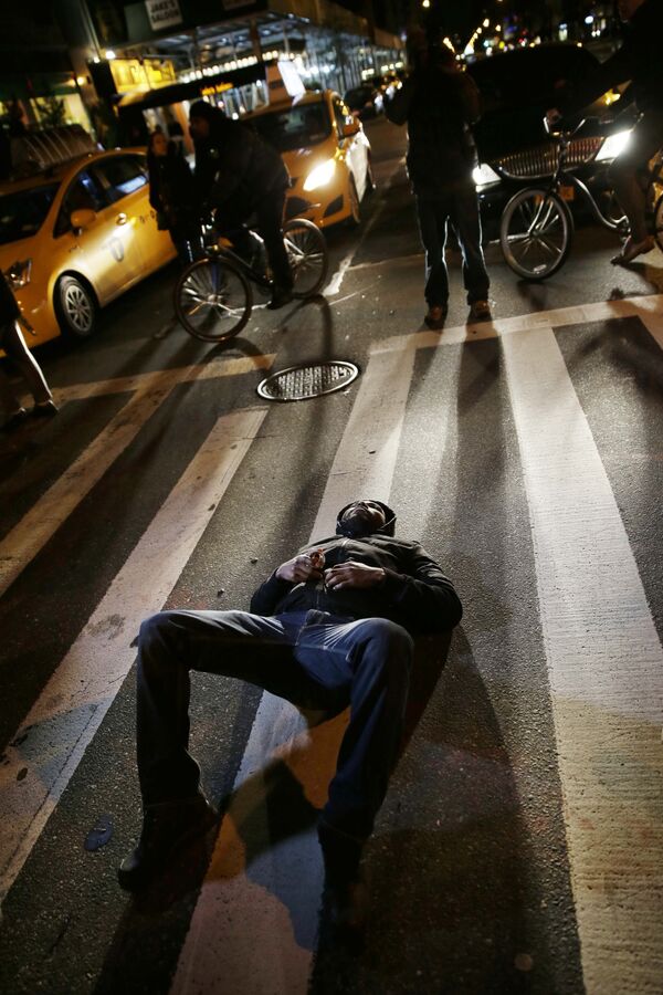 Протестующий блокирует дорогу во время марша в ответ на решение большого жюри по делу Эрика Гарнера в Нью-Йорке