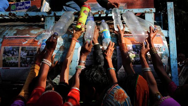 Индийские женщины участвующие в митинге в Нью-Дели, стоят в очереди за питьевой водой. Архивное фото