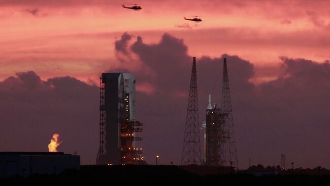 Военные вертолеты пролетают над стартовой площадкой космического корабля Orion