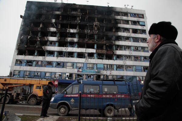 Мужчина смотрит на здание Дома Печати в центре Грозного