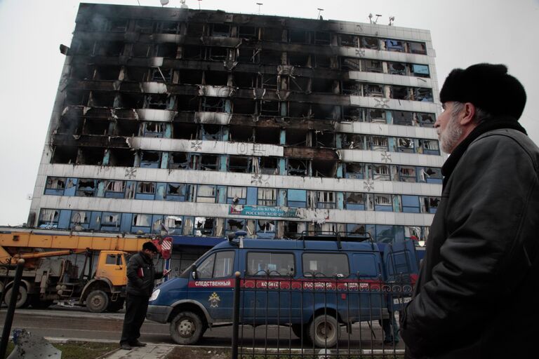 Мужчина смотрит на здание Дома Печати в центре Грозного