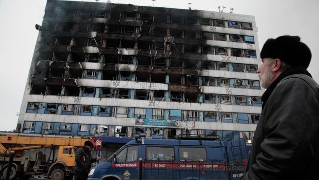 Мужчина смотрит на здание Дома Печати в центре Грозного