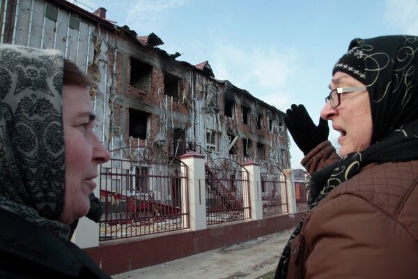 Женщины у поврежденной школы №20 в центре Грозного