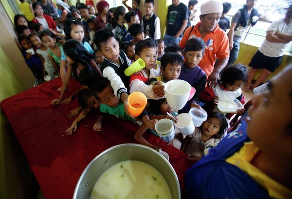 Дети стоят в очереди за едой в эвакуационном центре
