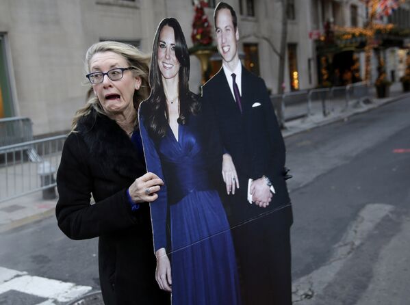 Женщина с вырезанными фигурами принца Уильяма и герцогини Кембриджской Кейт в Нью-Йорке. 7 декабря 2014